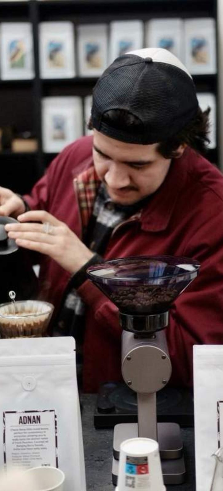 Barista weighing coffee at a stand